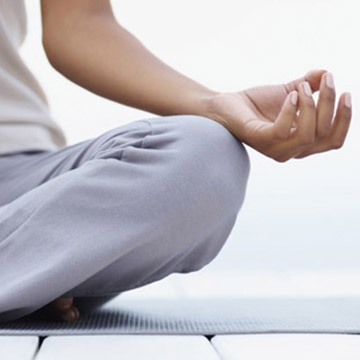 A person sits in a meditative, cross-legged position.